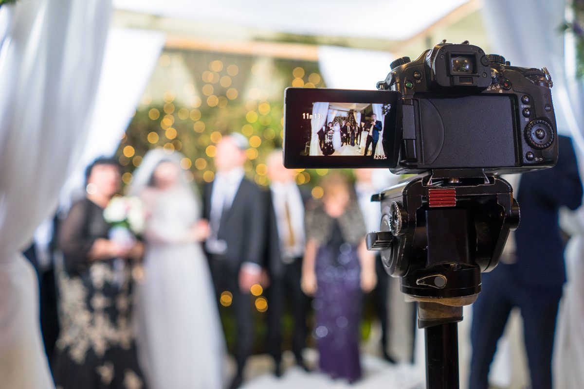 Câmera em tripé filmando a cerimônia de um casamento