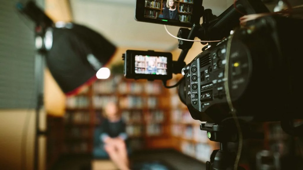 Câmera de cinema e monitores gravando uma entrevista institucional