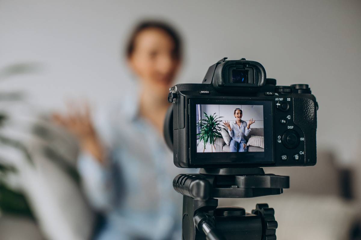 Câmera da Kino Films em tripé gravando um depoimento, com a entrevistada aparecendo na tela